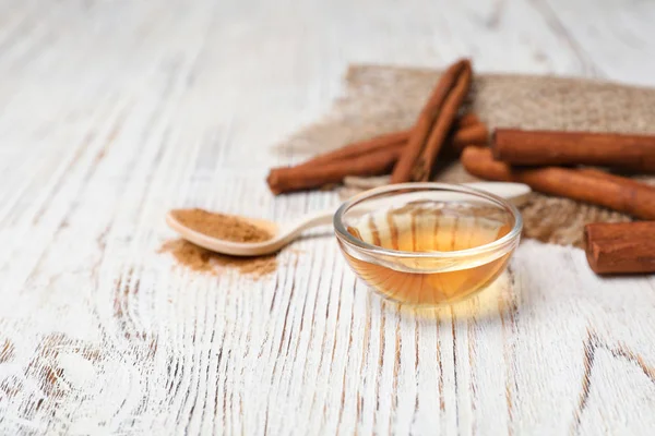 Tazón pequeño con aceite esencial de canela sobre mesa de madera — Foto de Stock