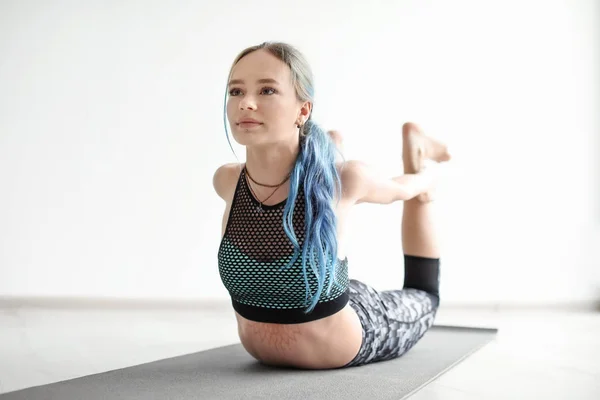 Giovane donna che pratica yoga al chiuso — Foto Stock