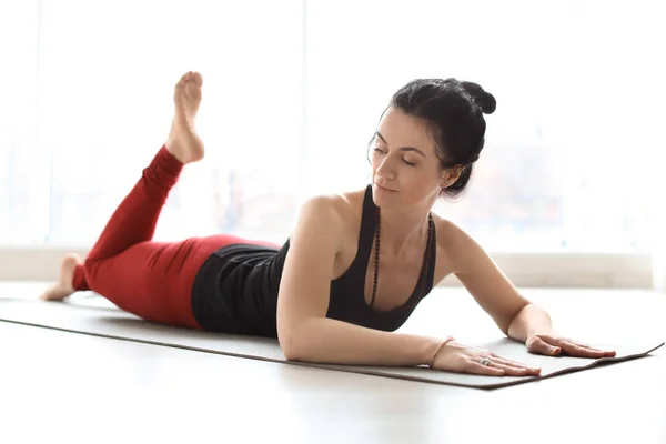 Mujer deportiva practicando yoga en interiores — Foto de Stock