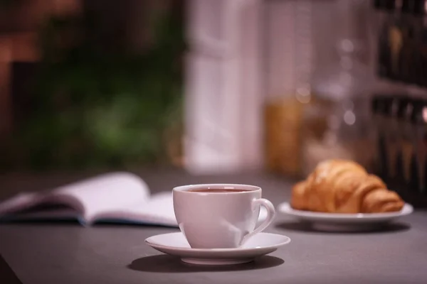 Tasse heißen Kaffee auf verschwommenem Hintergrund — Stockfoto