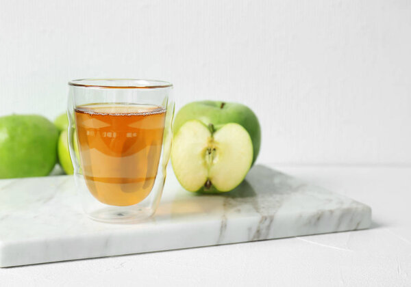 Glass of apple juice on marble board
