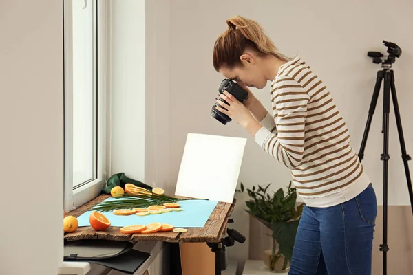 Mulher tirando foto de frutas cortadas e folha de palma na soleira da janela. Fotografia alimentar — Fotografia de Stock