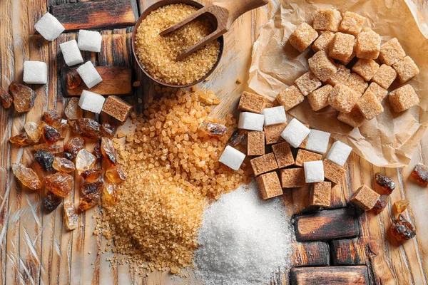 Flat lay composition with different types of sugar on wooden table — Stock Photo, Image