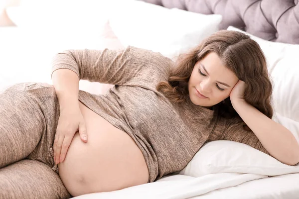 젊은 임신 부 집에서 침대에 누워 — 스톡 사진