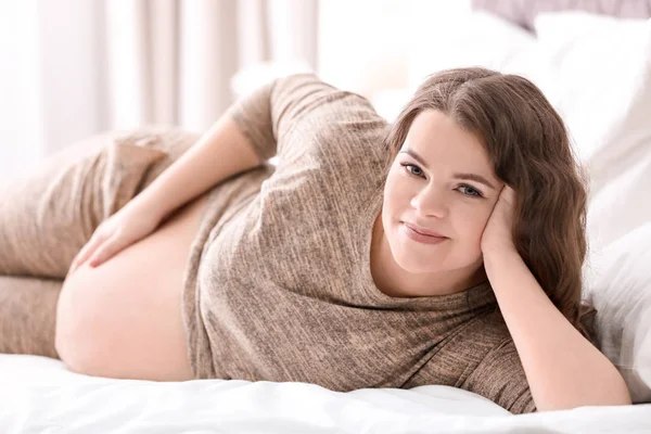 Молода вагітна жінка лежить на ліжку вдома — стокове фото