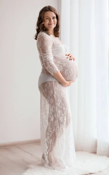 Молода вагітна жінка в елегантній сукні вдома — стокове фото