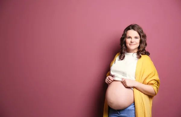 Hamile kadında genç: renk arka plan üzerinde rahat kıyafetler — Stok fotoğraf