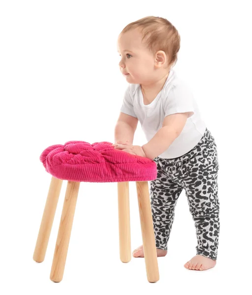 Cute baby holding on to stool on white background. Learning to walk — Stock Photo, Image