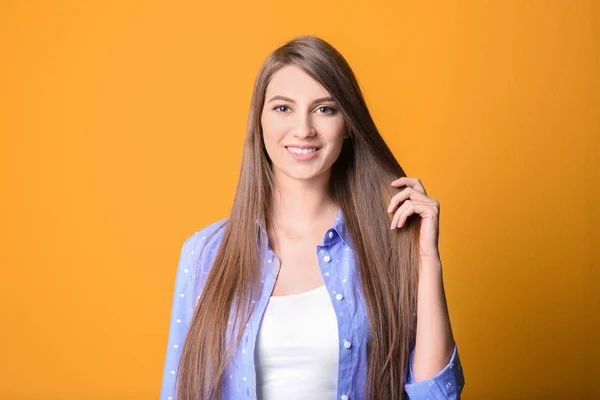 Retrato de mulher jovem com cabelo longo e bonito em fundo de cor — Fotografia de Stock