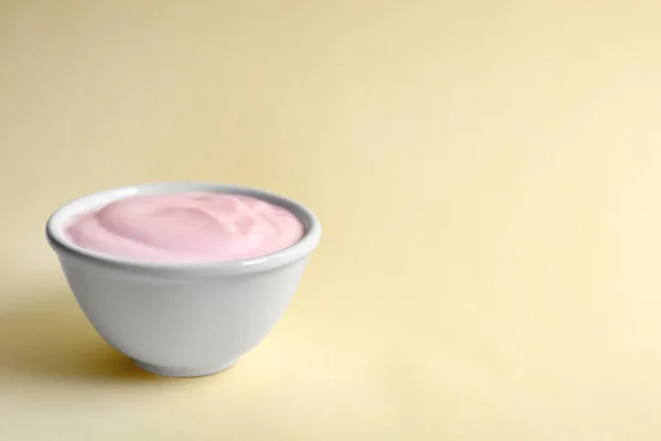 Ciotola con gustoso yogurt su sfondo a colori — Foto Stock