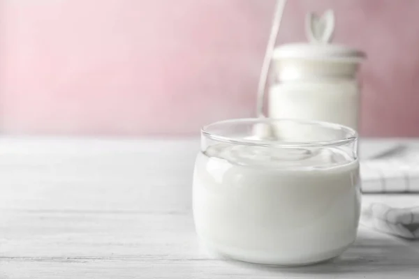 Glasburk välsmakande med yoghurt på träbord — Stockfoto