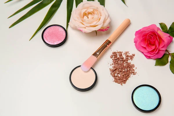 Sammansättning med makeup borste, kosmetiska produkter och rosor på vit bakgrund — Stockfoto