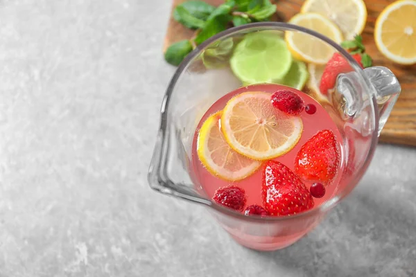 Jarra de limonada fresca con bayas en la mesa —  Fotos de Stock