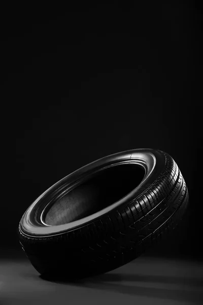 Nouveau pneu de voiture sur fond noir — Photo
