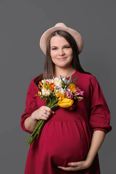 Mulher grávida bonita com flores no fundo de cor — Fotografia de Stock