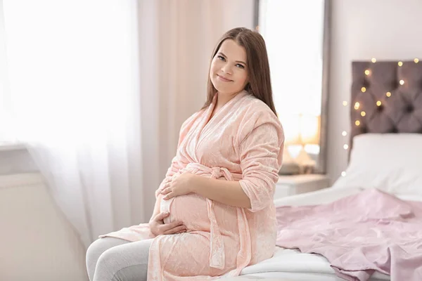 Mooie zwangere vrouw zittend op bed thuis — Stockfoto