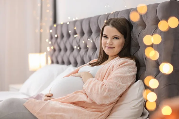 Красива вагітна жінка лежить на ліжку вдома — стокове фото