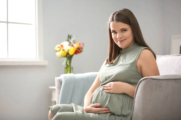 Красива вагітна жінка сидить у кріслі вдома — стокове фото