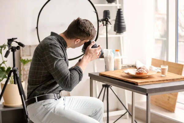 Jeune homme prenant des photos de nourriture en studio photo — Photo