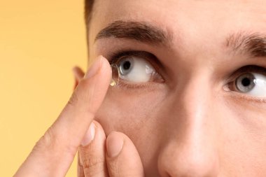 Koyarak Kontakt lens renk arka plan üzerinde onun gözünde genç adam