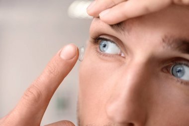 Onun gözünde ışık arka plan üzerine koyarak Kontakt lens genç adam