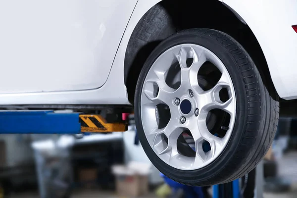 Car on lift at tire service, closeup