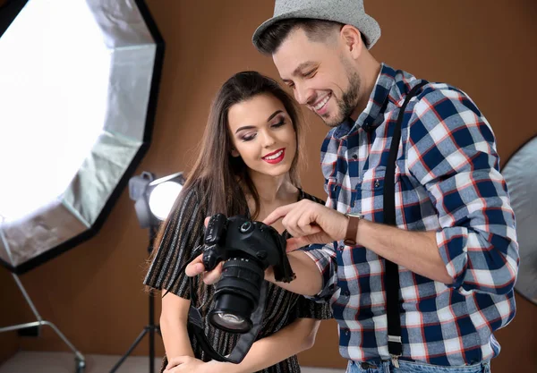 Modelo jovem bonito com fotógrafo profissional em estúdio — Fotografia de Stock