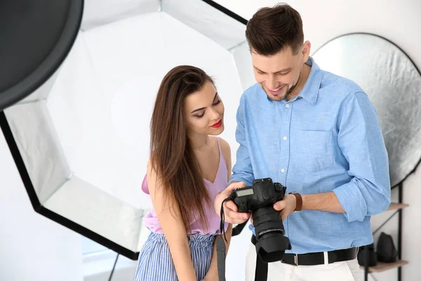 Modelo jovem bonito com fotógrafo profissional em estúdio — Fotografia de Stock