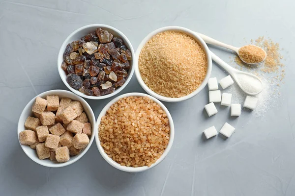 Composición plana con diferentes tipos de azúcar sobre fondo gris —  Fotos de Stock
