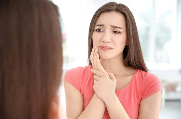 Αντανάκλαση της γυναίκας με ευαίσθητα δόντια στον καθρέφτη σε εσωτερικούς χώρους — Φωτογραφία Αρχείου