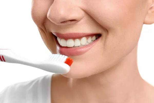 Jovem mulher escovando os dentes no fundo branco, close-up — Fotografia de Stock