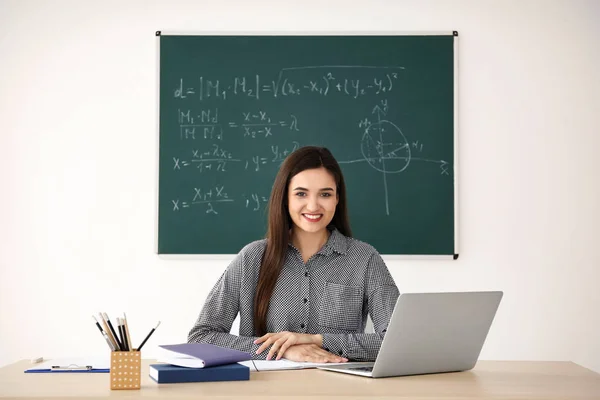 Profesora joven trabajando en la mesa en el aula — Foto de Stock