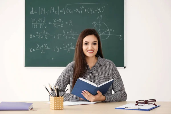 Jonge vrouwelijke leraar werken aan tafel in de klas — Stockfoto