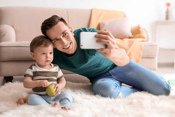 Jonge vader met zijn schattige zoontje thuis selfie te nemen — Stockfoto