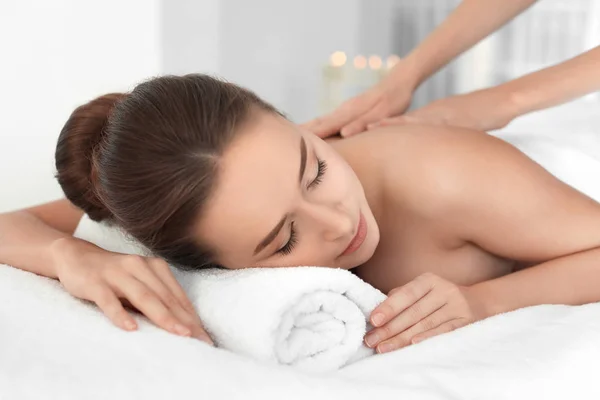 Jonge vrouw genieten van massage in spa salon — Stockfoto