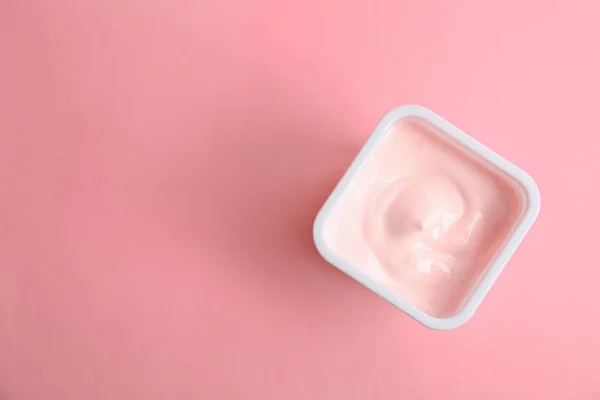 Plastový pohár s chutný jogurt na barvu pozadí, pohled shora — Stock fotografie