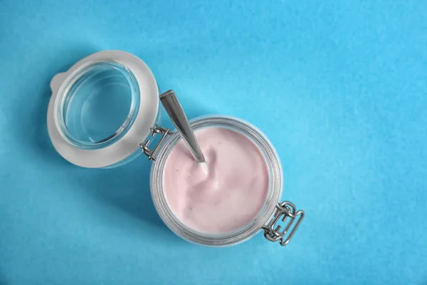 Frasco com iogurte saboroso no fundo de cor, vista superior — Fotografia de Stock