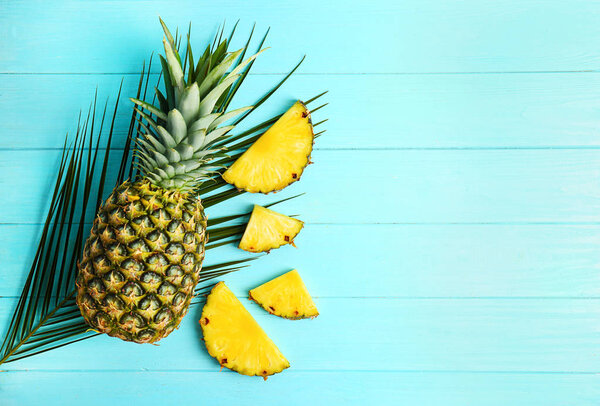 Fresh pineapples on color wooden background