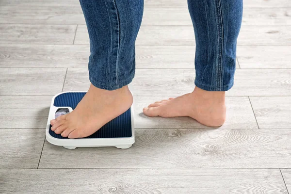 Mujer con sobrepeso usando escamas en interiores — Foto de Stock