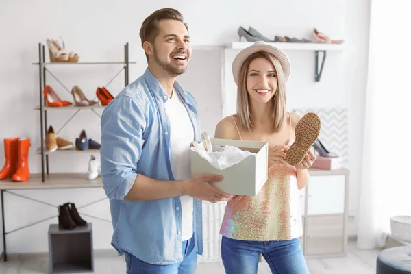 Pareja joven eligiendo zapatos en la tienda — Foto de Stock