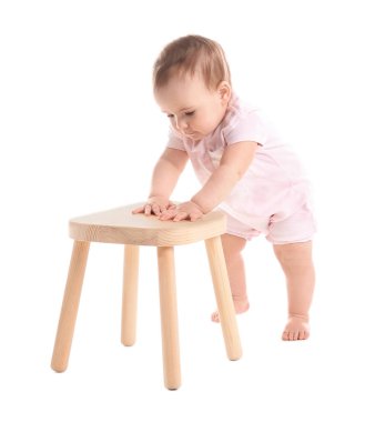Beyaz arka plan üzerinde ahşap dışkı üzerinde tutan şirin bebek. Yürümeyi öğrenme