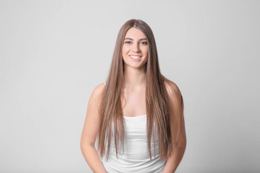 Işık arka plan üzerinde uzun güzel saçlı genç kadın portresi