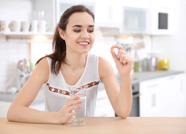 Mladá žena užívat tabletu vitamínů uvnitř — Stock fotografie