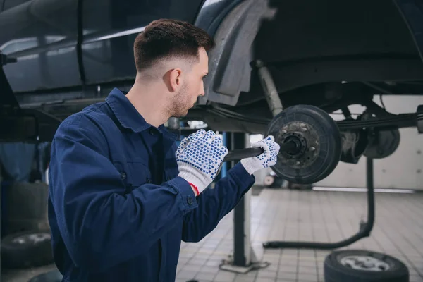 Young mechanic changing wheel at tire service — Stock Photo, Image