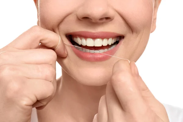 Jovem mulher fio dental seus dentes no fundo branco, close-up — Fotografia de Stock