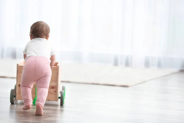 Χαριτωμένο μωρό εκμετάλλευση σε ξύλινο καλάθι στο σπίτι. Μαθαίνουν να περπατούν — Φωτογραφία Αρχείου