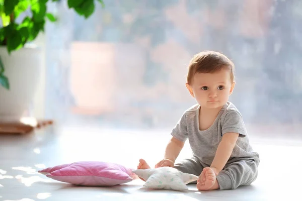 실내 창 근처 바닥에 앉아있는 귀여운 아기 — 스톡 사진