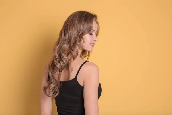 Retrato de mulher jovem com cabelo longo e bonito em fundo de cor — Fotografia de Stock