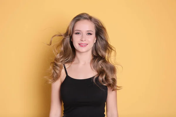 Porträtt av ung kvinna med långa vackra hår färg bakgrunden — Stockfoto
