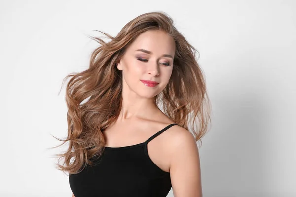 Retrato de mulher jovem com cabelos longos e bonitos no fundo claro — Fotografia de Stock